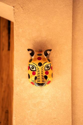 a mask hanging on the side of a wall at La Paranera Hotel & Relax in Comala