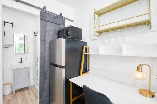 a kitchen with a refrigerator and a table with chairs at Tiny Living; Big Style in Oakland