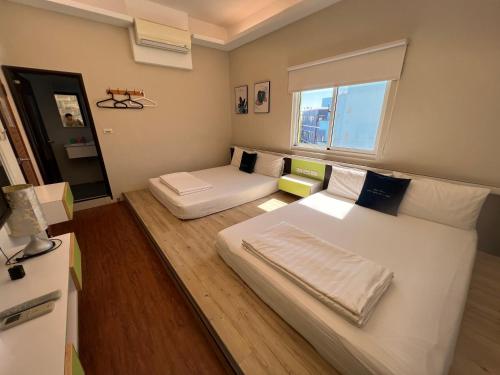 a small room with two beds and a window at Group Sea Bed and Breakfast in Xiaoliuqiu