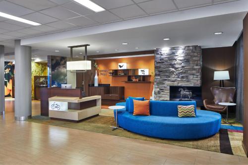 a lobby with a blue couch and a fireplace at Fairfield Inn & Suites by Marriott Atlanta Lithia Springs in Lithia Springs