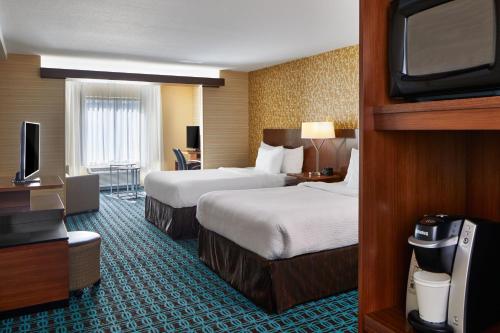 a hotel room with two beds and a flat screen tv at Fairfield Inn & Suites by Marriott Atlanta Lithia Springs in Lithia Springs