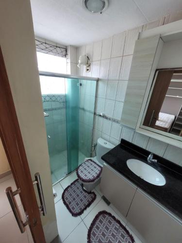 a bathroom with a sink and a toilet and a mirror at Apartamento Conforto/Praticidade in Manaus
