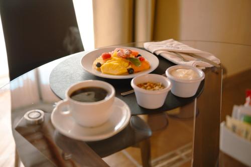 a table with a plate of food and a cup of coffee at BOTANIQ HOTEL BOUTIQUE in Valle de Bravo