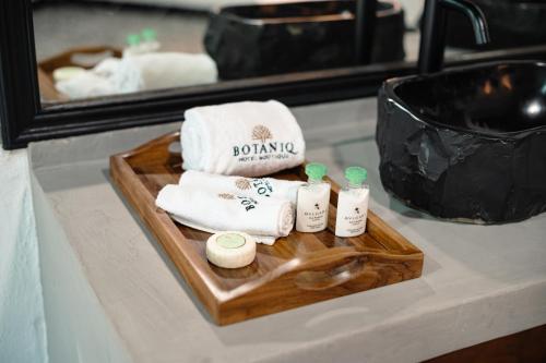 a tray with towels on a bathroom counter with a mirror at BOTANIQ HOTEL BOUTIQUE in Valle de Bravo