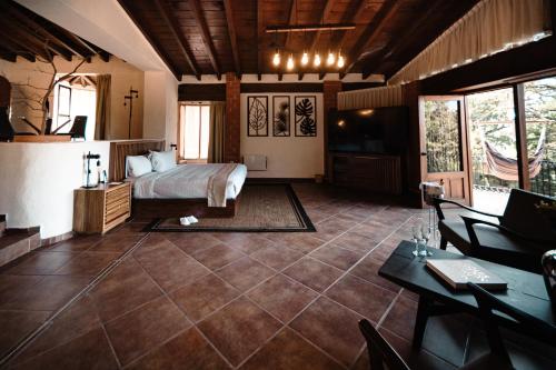 a bedroom with a bed and a desk and a tv at BOTANIQ HOTEL BOUTIQUE in Valle de Bravo