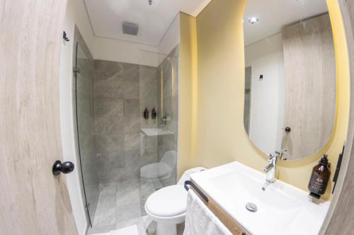 y baño con lavabo, ducha y aseo. en Sonata 44 Hotel Laureles, en Medellín