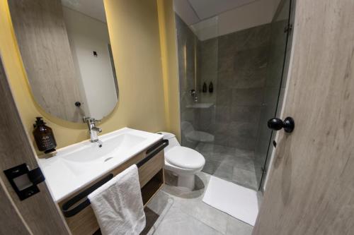 a bathroom with a sink and a toilet and a mirror at Sonata 44 Hotel Laureles in Medellín