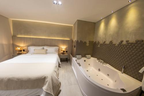 a bedroom with a bed and a bath tub at Sonata 44 Hotel Laureles in Medellín