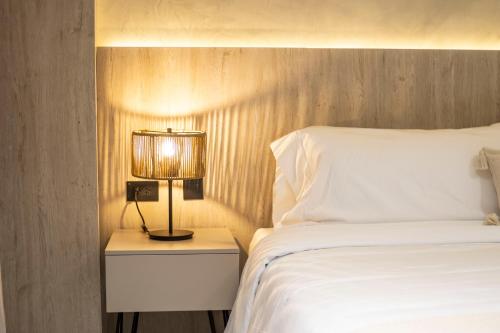 a bedroom with a bed and a lamp on a night stand at Sonata 44 Hotel Laureles in Medellín
