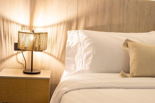a bedroom with a bed with a lamp on a night stand at Sonata 44 Hotel Laureles in Medellín