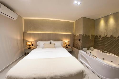 a bedroom with a large bed and a bath tub at Sonata 44 Hotel Laureles in Medellín