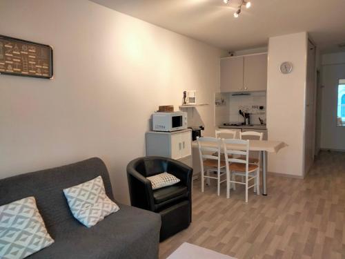 un salon avec un canapé et une table et une cuisine dans l'établissement Studio Central à 100m Plage avec Balcon et Commodités, Les Sables-d'Olonne - FR-1-331-61, à Les Sables-dʼOlonne