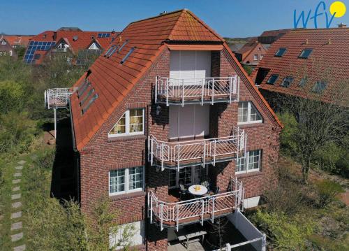 un edificio de apartamentos con balcones en un lateral en Luv und Lee - Ferienwohnung Juister Stuv en Juist