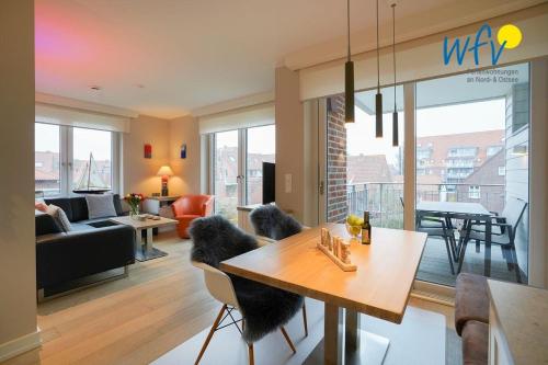 a living room with a table and chairs and a living room at Achterhus - Ferienwohnung Wattwurm in Juist