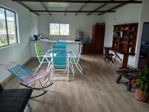 een woonkamer met stoelen, een tafel en een aanrecht bij Villa el Eden in Sutamarchán