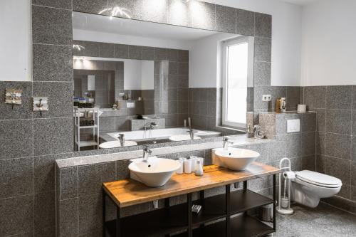 a bathroom with two sinks and a toilet and a mirror at Kaminstube im Goethequartier in Bremerhaven