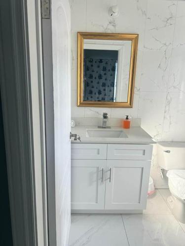 a white bathroom with a sink and a mirror at CLIFF POINT in Treasure Beach