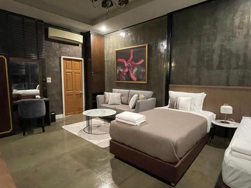 356 Hostel في Thung Song: غرفة نوم بسرير واريكة وطاولة