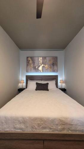 a bedroom with a large white bed with two lamps at Trujillo Alto Quiet and Cozy, Fully Equipped and Pet-Friendly in Trujillo Alto