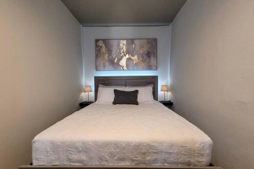 a bedroom with a white bed with two lamps at Trujillo Alto Quiet and Cozy, Fully Equipped and Pet-Friendly in Trujillo Alto