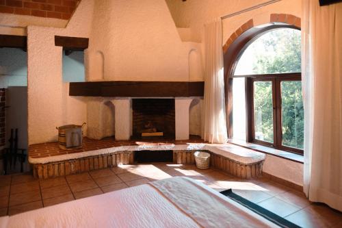 a room with a fireplace and a large window at BOTANIQ HOTEL BOUTIQUE in Valle de Bravo
