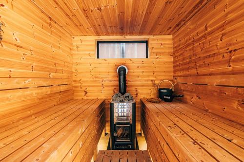 a wooden cabin with a stove in the middle at サウナ付き一棟貸し宿 大岡辻-tsuji oooka- in Ookanakamaki