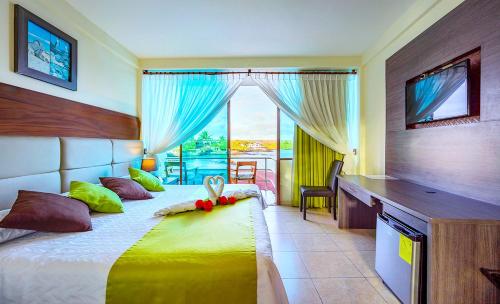 a bedroom with a bed with a desk and a window at Hotel Solymar in Puerto Ayora