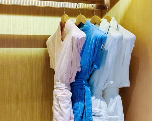 a bunch of clothes are hanging on a rack at Mehood Elegant Hotel Guangzhou Baiyun Airport Huadu Cultural Tourism City in Huadong