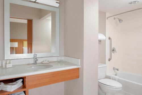 a bathroom with a sink and a toilet and a mirror at SpringHill Suites Cincinnati North Forest Park in Springdale