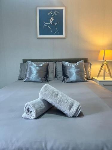 a bed with a towel laying on top of it at Modern Apartment In The Heart Of Kensington in Liverpool