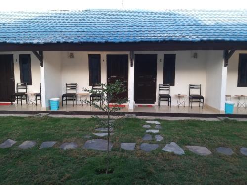 uma casa com cadeiras e mesas e um telhado azul em Aipayung Homestay 