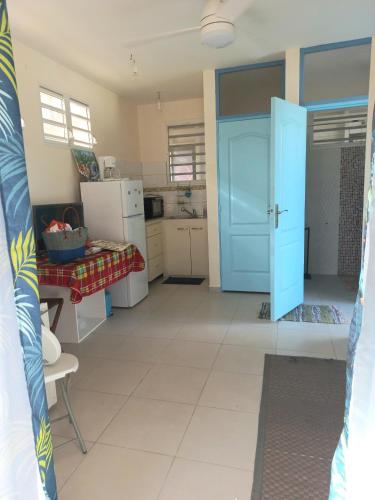 um quarto com uma porta azul e uma cozinha em ChezLou1 em Fort-de-France