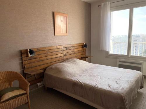 une chambre avec un grand lit et une fenêtre dans l'établissement Appartement rénové, vue mer, proche plage, 1 chambre, balcon - FR-1-323-515, à Saint-Jean-de-Monts