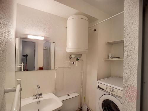 une salle de bain blanche avec un lavabo et des toilettes dans l'établissement Charmant F2 avec Balcons, Proche Thermes, Animaux Acceptés, Wifi, Ascenseur, Parking Gratuit - FR-1-451-206, à Lamalou-les-Bains
