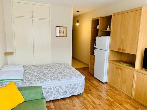Cette petite chambre comprend un lit et un réfrigérateur blanc. dans l'établissement Studio cosy avec loggia - 2 pers. - Centre-ville et cures à proximité, animaux acceptés - FR-1-703-172, à Amélie-les-Bains-Palalda