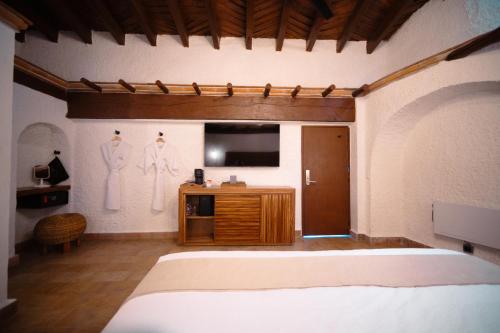 a bedroom with a bed and a flat screen tv at BOTANIQ HOTEL BOUTIQUE in Valle de Bravo