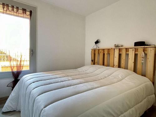 une chambre avec un grand lit blanc avec une fenêtre dans l'établissement Appartement cosy 4 pers. à 400m de la plage, piscine, terrasse, parking sécurisé - FR-1-225-807, à Argelès-sur-Mer