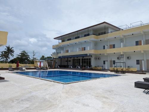 een hotel met een zwembad voor een gebouw bij Hotel Apex Dobo in Dobo