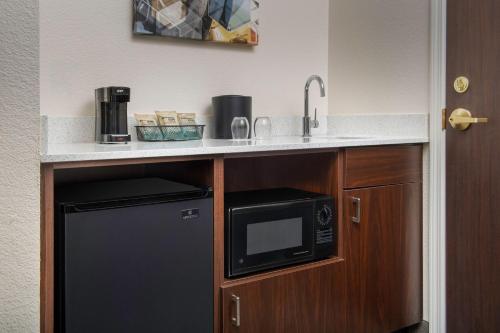 a kitchen with a counter with a sink and a microwave at SpringHill Suites Dallas Addison/Quorum Drive in Addison