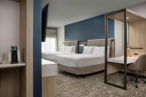 a hotel room with two beds and a desk at SpringHill Suites by Marriott Birmingham Gardendale in Gardendale