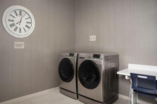 a room with a washing machine and a clock on the wall at SpringHill Suites by Marriott Birmingham Gardendale in Gardendale