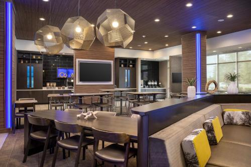 a restaurant with tables and chairs and a bar at SpringHill Suites by Marriott Birmingham Gardendale in Gardendale