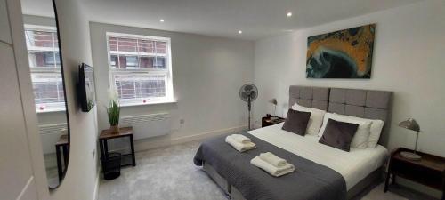 a bedroom with a bed with two towels on it at Modern 1 Bedroom Apartment Town Centre Camberley in Camberley