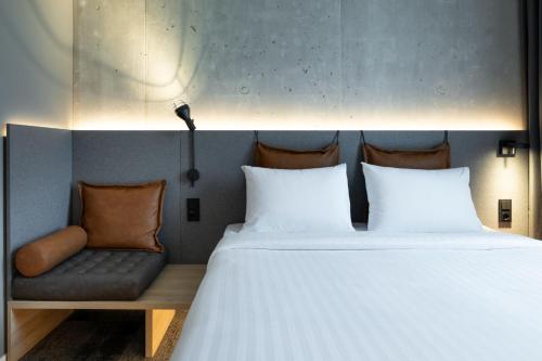 a bedroom with a bed and a couch at Moxy Outletcity Metzingen in Metzingen