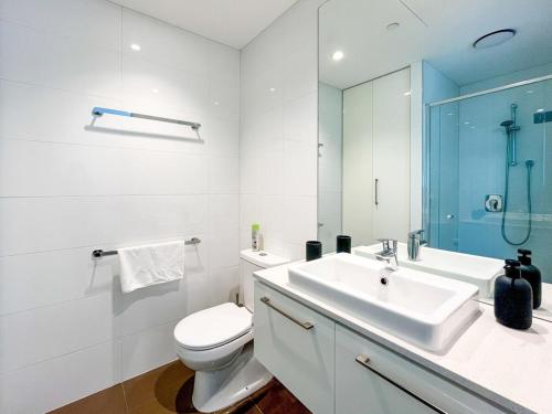 a bathroom with a sink and a toilet and a mirror at Pride CBD Skyline View 2B2B Apartment LV32 in Melbourne