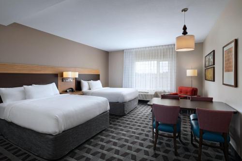 a hotel room with two beds and a desk at TownePlace Suites by Marriott Edgewood Aberdeen in Belcamp