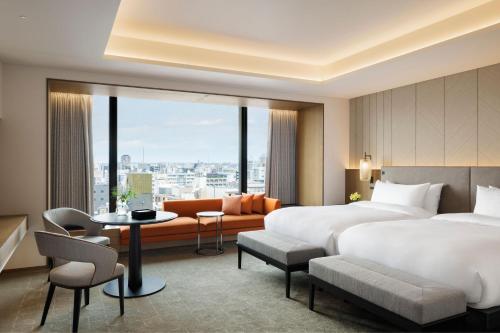 a hotel room with two beds and a table and chairs at TIAD, Autograph Collection in Nagoya