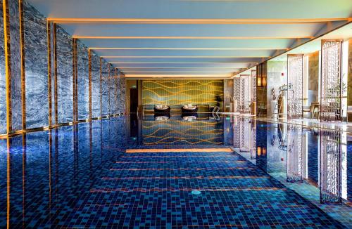 a pool in a hotel lobby with blue tiles at Wanda Realm Hotel Tai'an in Tai'an