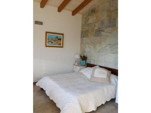 um quarto com uma cama e uma parede de pedra em Falco Cascina Borchina em Musignano