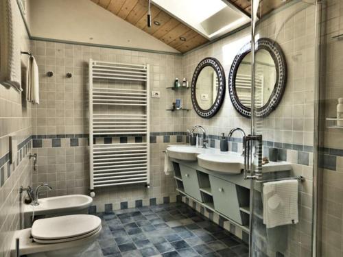 een badkamer met 2 wastafels, een toilet en een douche bij Holiday home Casa Nanda in Mombaruzzo